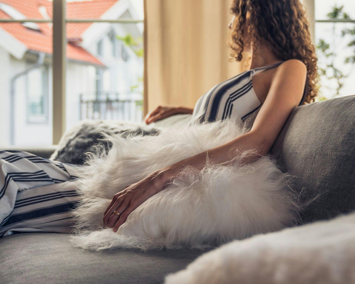 woman on couch with fur pillow