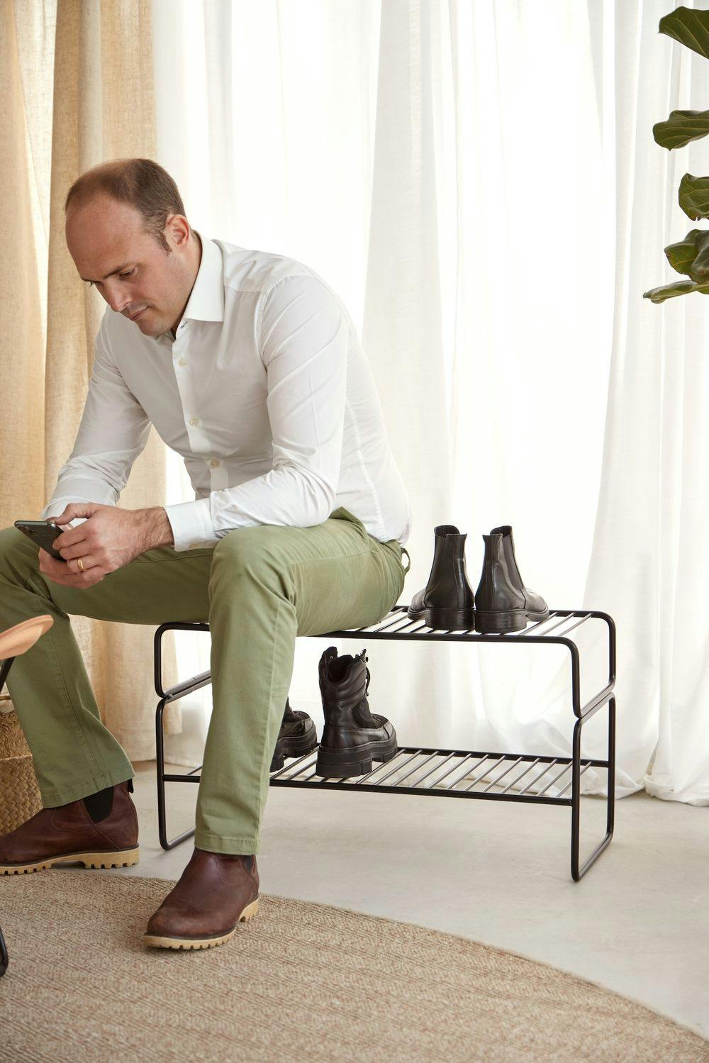Design-Schuhregal mit einer Person darauf sitzend