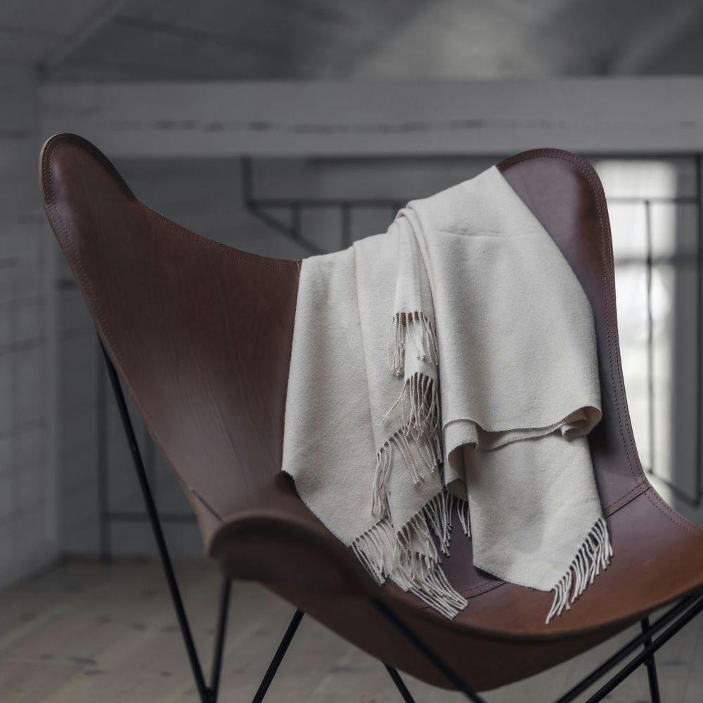 dark brown leather butterfly chair with blanket