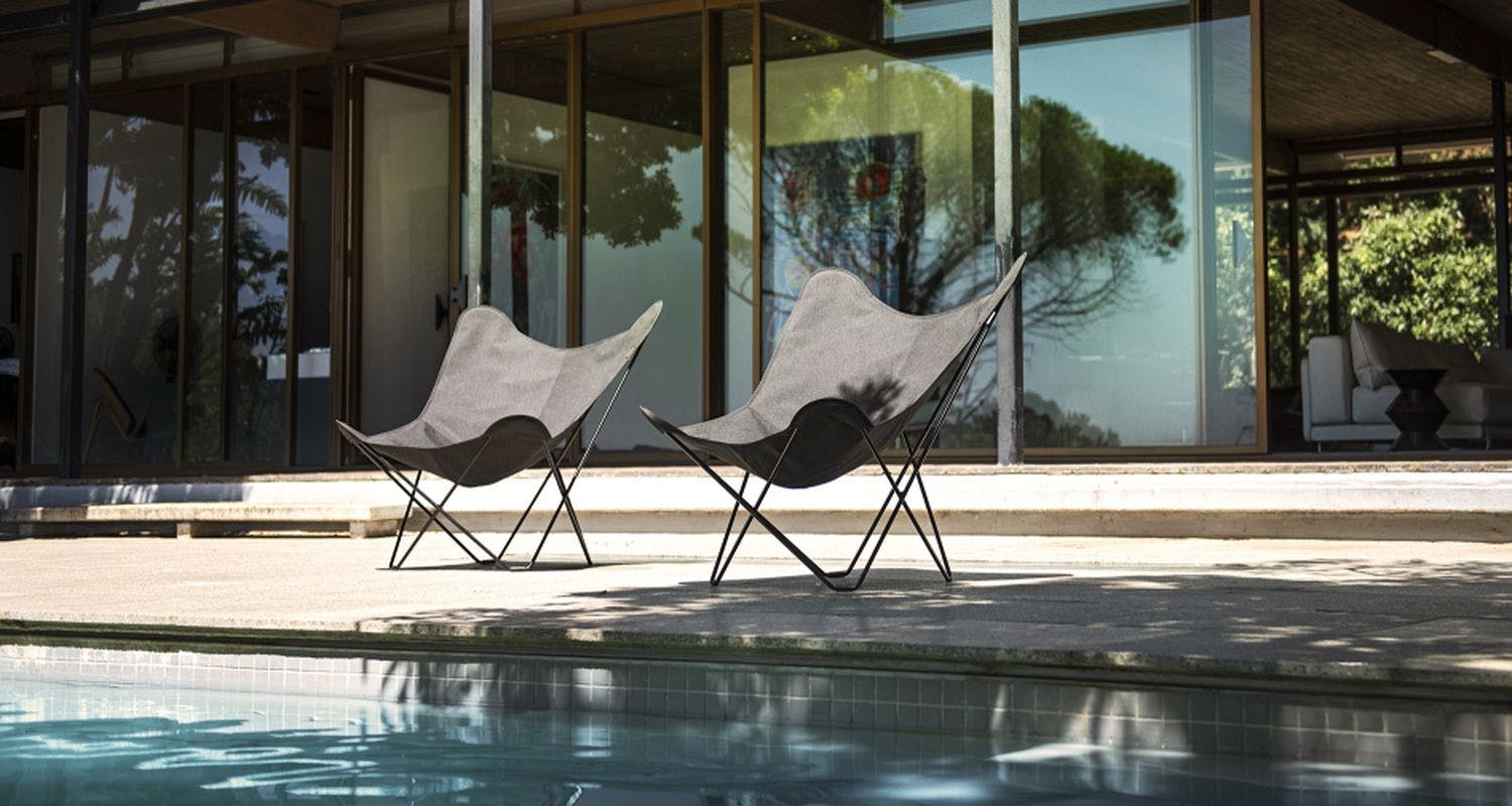 black outdoor butterfly chair in sunny pool edge